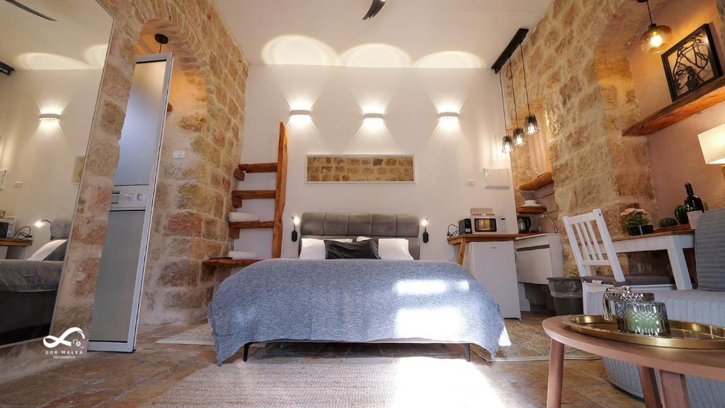 ein Schlafzimmer mit einem Bett und einem Tisch in einem Zimmer in der Unterkunft Mamila space in Jerusalem