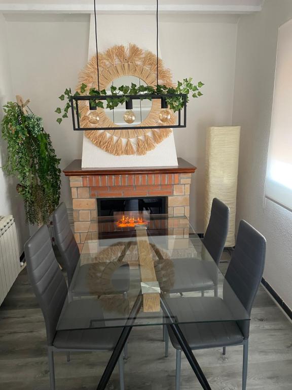 une salle à manger avec une table en verre et une cheminée dans l'établissement Apartamento El Cuco, à Candeleda