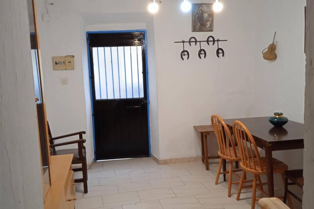 una cocina con mesa y sillas y una puerta negra en La Casa los Trancos, muy cerca de Cazorla, en Peal de Becerro
