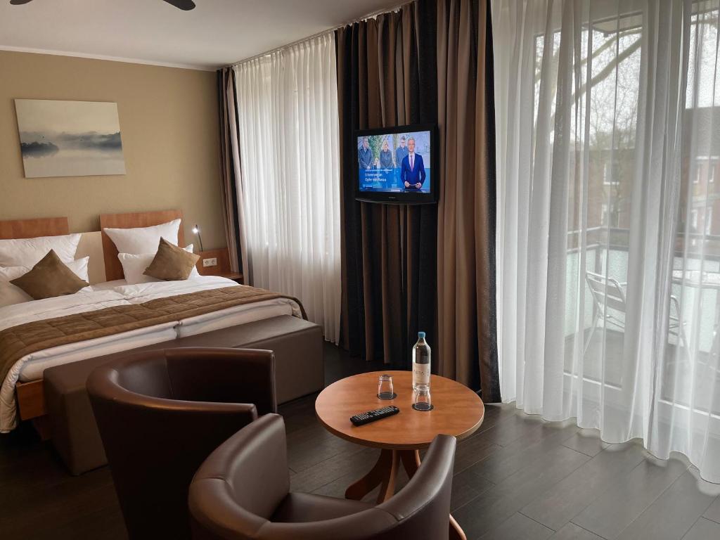 a hotel room with a bed and a table and a television at Hotel Jellentrup in Münster