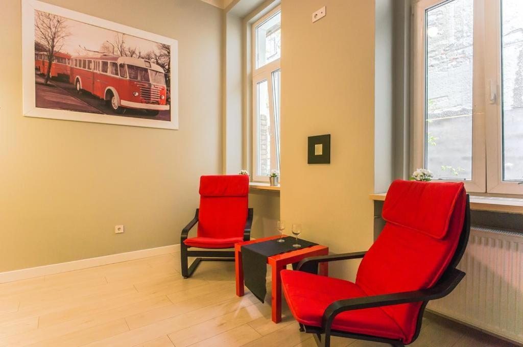 twee rode stoelen en een tafel in een kamer bij Apartments Síp in Boedapest