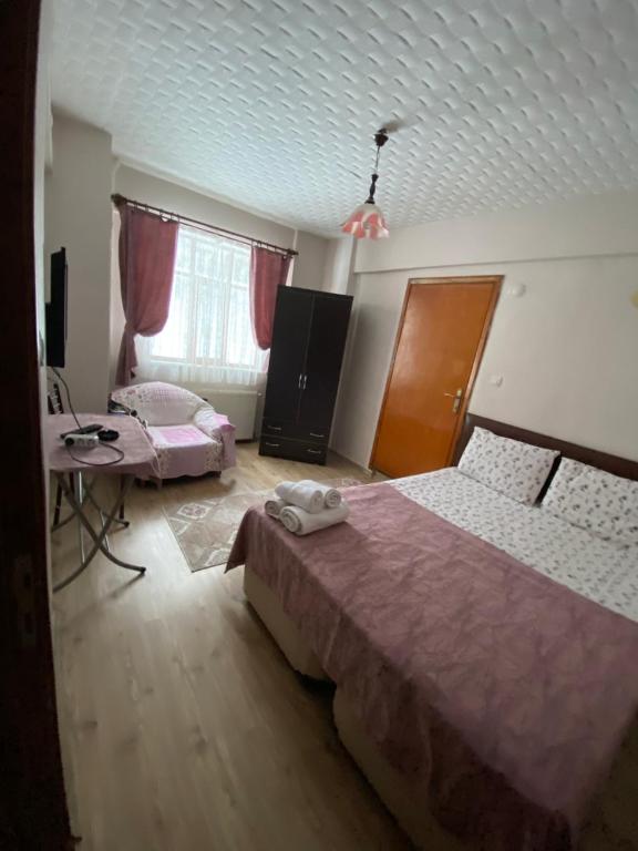 a bedroom with two beds and a desk and a television at Abant Barış Pansiyon in Dereceören