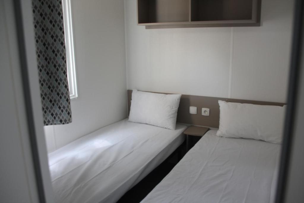 Łóżko lub łóżka w pokoju w obiekcie mobil home au lac des rêves