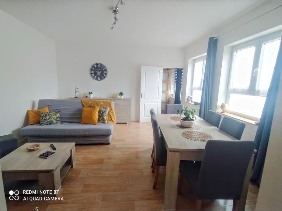 ein Wohnzimmer mit Tisch und Couch in der Unterkunft Appartement calme in La Montagne