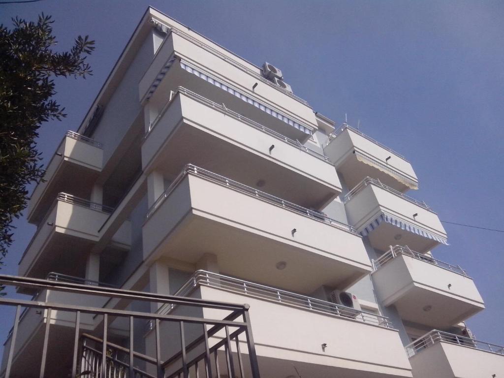 a white building with balconies on the side of it at Location Apartments in Herceg-Novi