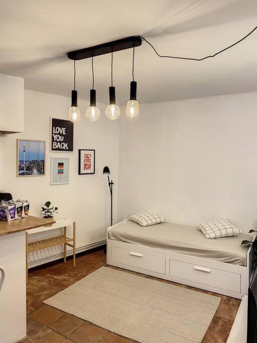Schlafzimmer mit einem Bett, einem Schreibtisch und Lampen in der Unterkunft IBIZA -Sublime studio Place de la Trinité- Netflix in Toulouse