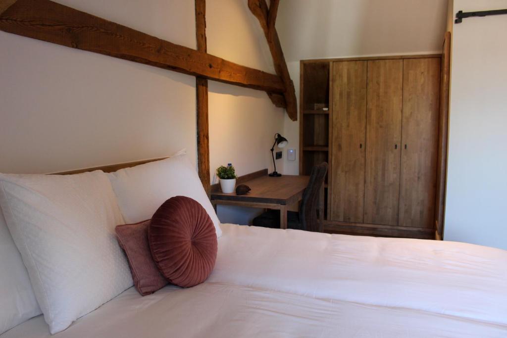 a bedroom with a white bed and a table at De Kasteelhoeve in Westmalle