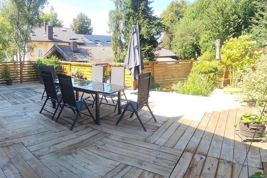 un patio con mesa, sillas y sombrilla en Sigrids Ferienwohnung Bad Tölz, en Bad Tölz