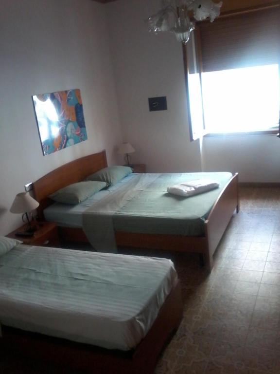 2 camas en una habitación de hotel con ventana en B&B Sea And Sardinia, en Alghero