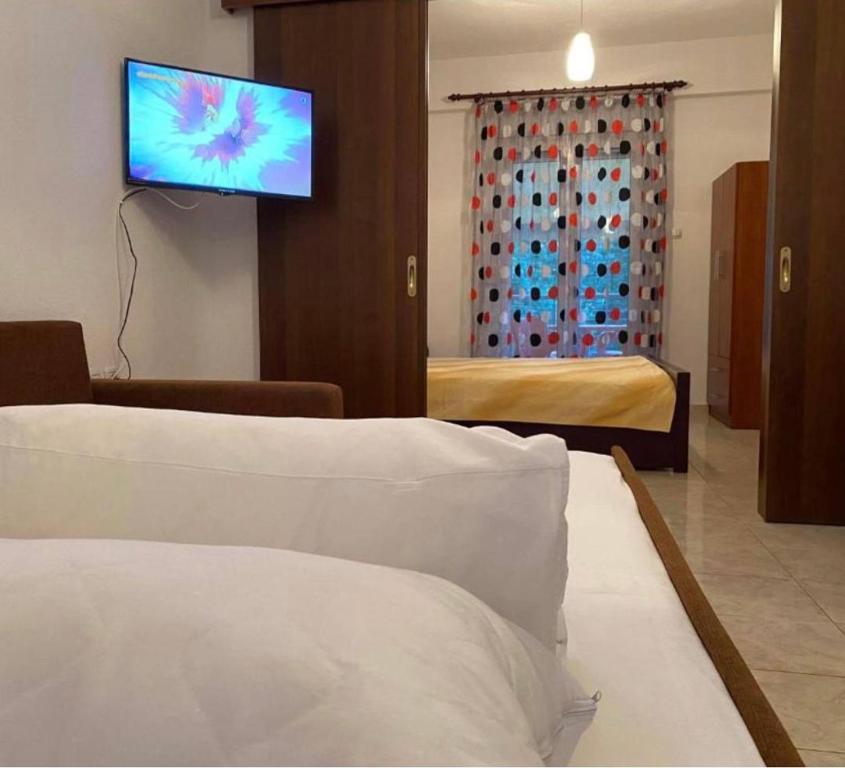 ein Hotelzimmer mit einem Bett und einem TV an der Wand in der Unterkunft Studio Nikol koutsoupia in Kókkinon Nerón
