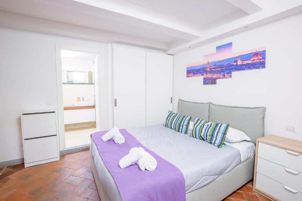 um quarto branco com uma cama com toalhas em UNYCA - Residenza San Niccolò em Florença