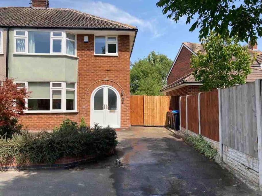 een stenen huis met een witte deur en een hek bij Renovated home, fab location, garden, pet friendly and parking in Chester