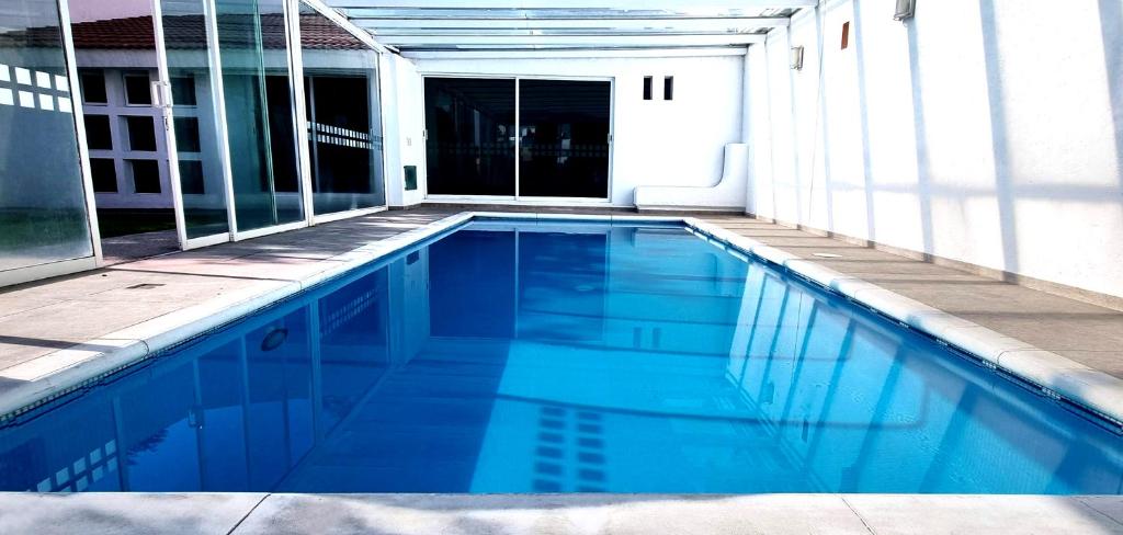 a swimming pool with blue water in a building at Departamento Vintage Querétaro in La Cañada