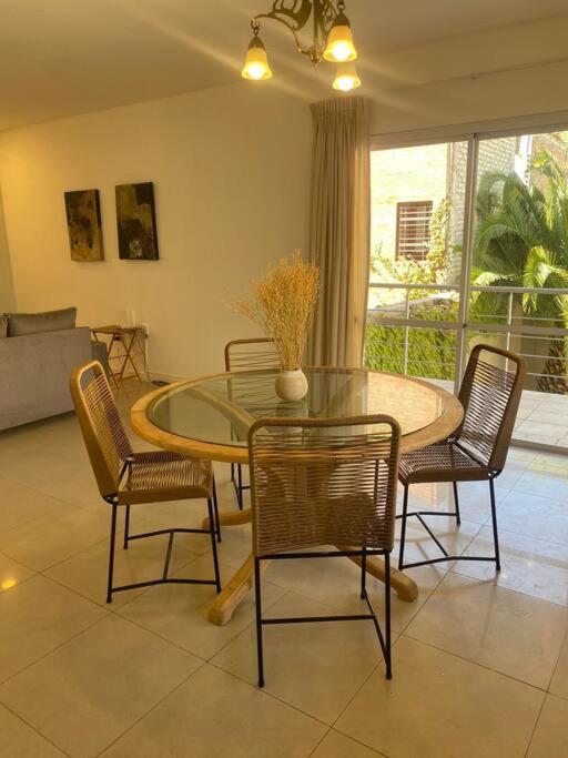 門多薩的住宿－departamento 2 dormitorios 2 baños，一间设有玻璃桌和椅子的用餐室