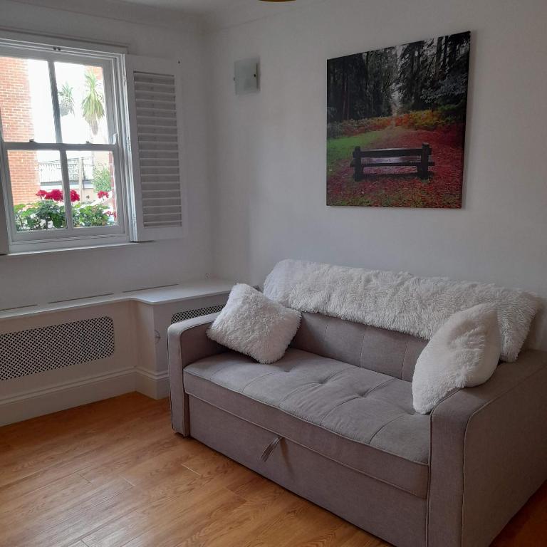 a living room with a couch and a window at The Hideaway in Swanage