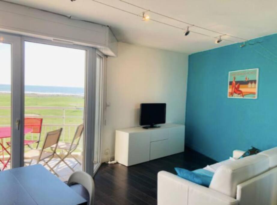 un salon avec un canapé et une télévision dans l'établissement Studio vue mer avec piscine, à Saint-Jean-de-Monts