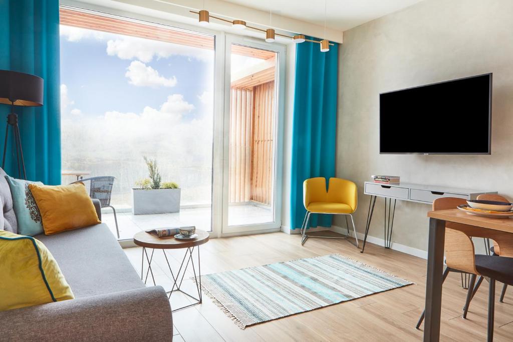 ein Wohnzimmer mit Sofa und Fernseher in der Unterkunft Laguna Resort Beskidy & Wellness in Zarzecze