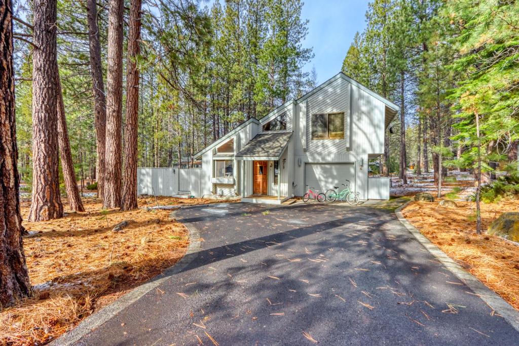 a house in the woods with a driveway at The Huckleberry Cabin in Sunriver