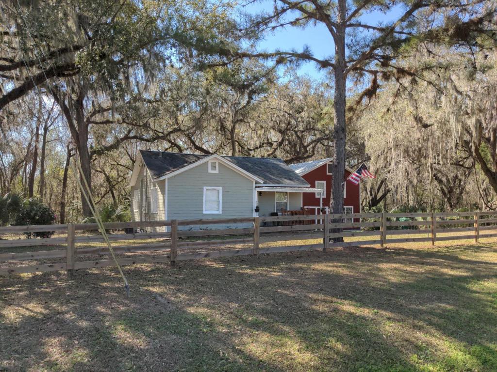 a house with a fence and an american flag at Micanopy Countyline Cottages in Micanopy