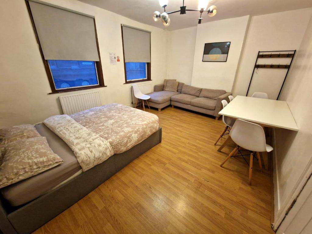 ロンドンにあるCity Budget Guesthouseのベッドルーム1室(ベッド1台、ソファ、テーブル付)