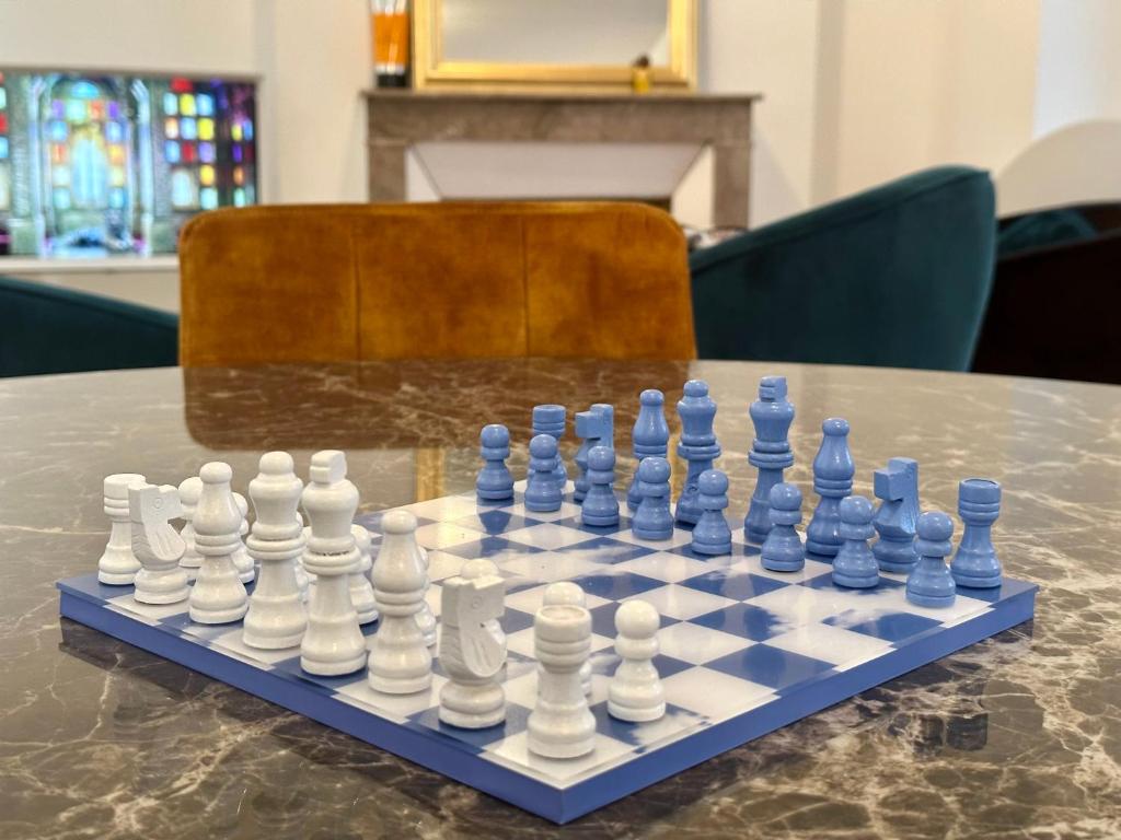 een schaakbord bovenop een tafel bij Bel Appartement avec parking au coeur de Reims in Reims