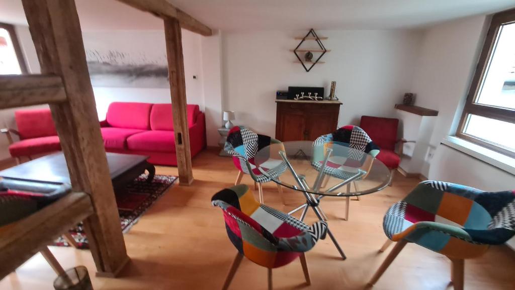 ein Wohnzimmer mit Stühlen und einem rosa Sofa in der Unterkunft Selestat entre Colmar et Strasbourg in Sélestat