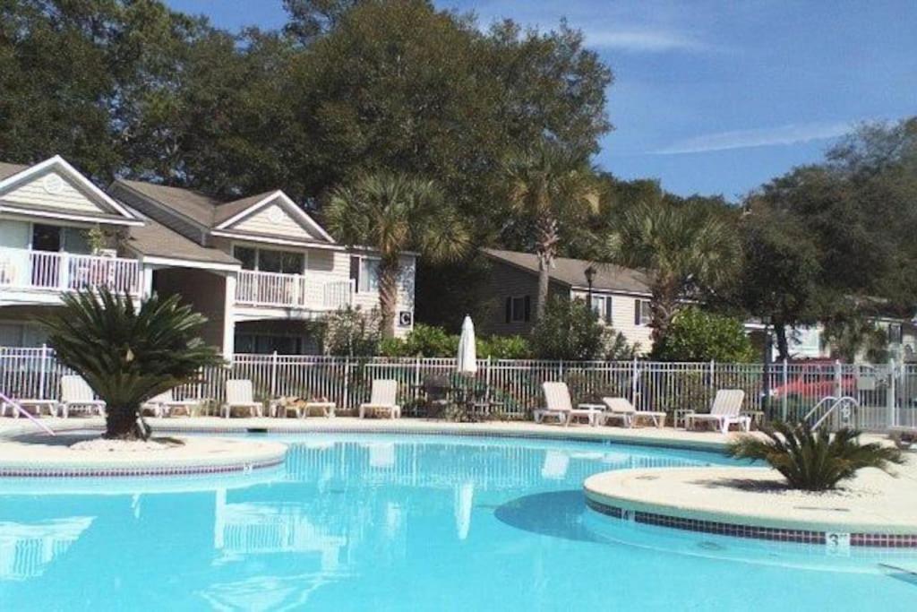 una grande piscina con sedie e recinzione di E10 comfortable and neat 2 bedroom 2 bath a Saint Simons Island