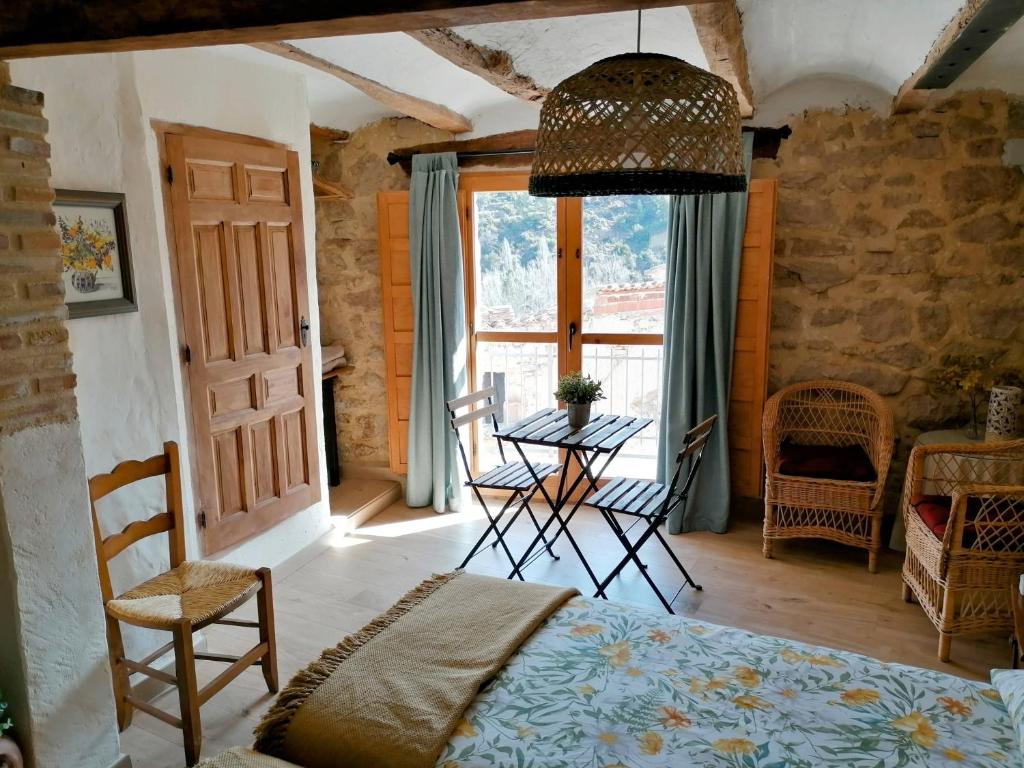 a bedroom with a bed and a table and a window at La Casirria in Olba
