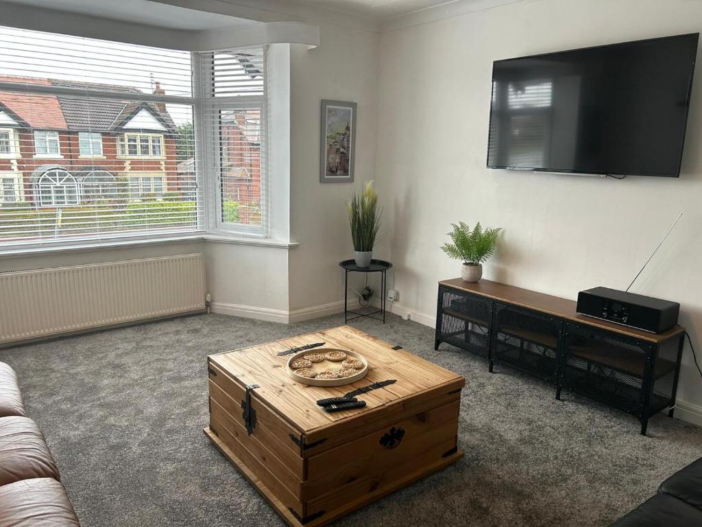 uma sala de estar com uma mesa de centro e uma televisão de ecrã plano em Light And Spacious Highcross Apartment em Poulton le Fylde