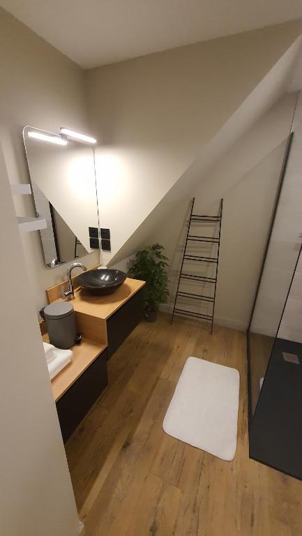uma casa de banho com um lavatório e uma escada num sótão em Votre chez vous em Bergheim