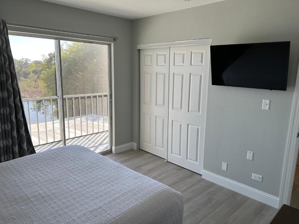 a bedroom with a bed and a flat screen tv at Marco Island Lakeside Inn in Marco Island