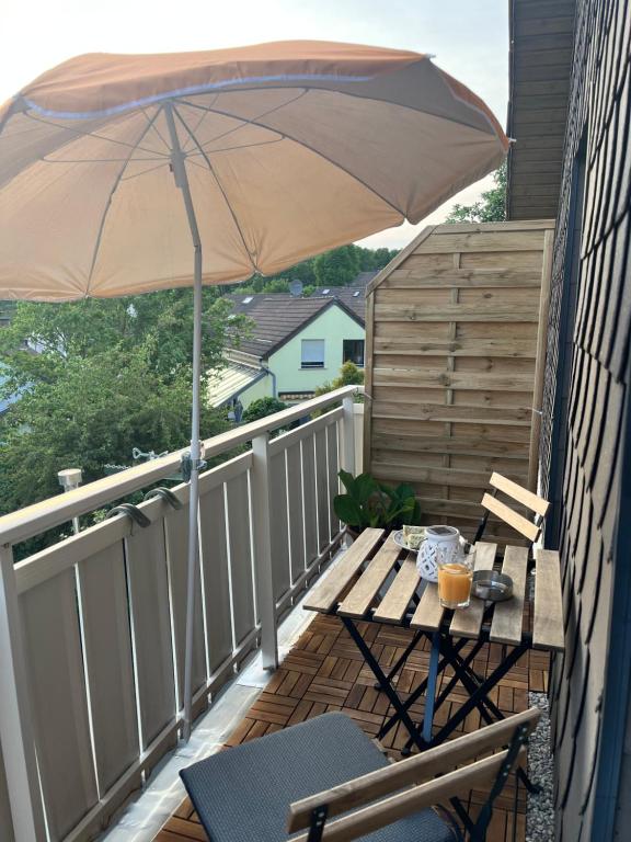 a patio with an umbrella and a table on a balcony at Ferienwohnung mit Fernblick in Hagen