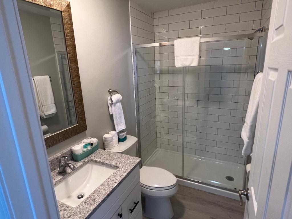a bathroom with a toilet and a sink and a shower at Marco Island Lakeside Inn in Marco Island