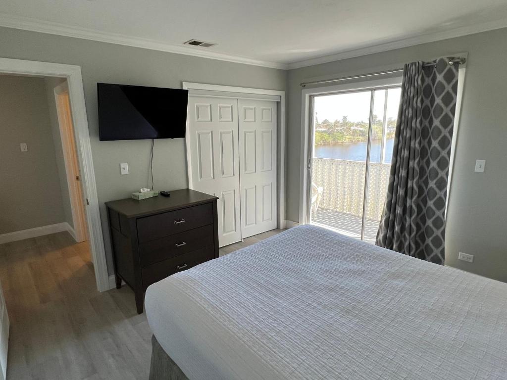 a bedroom with a bed and a television and a window at Marco Island Lakeside Inn in Marco Island