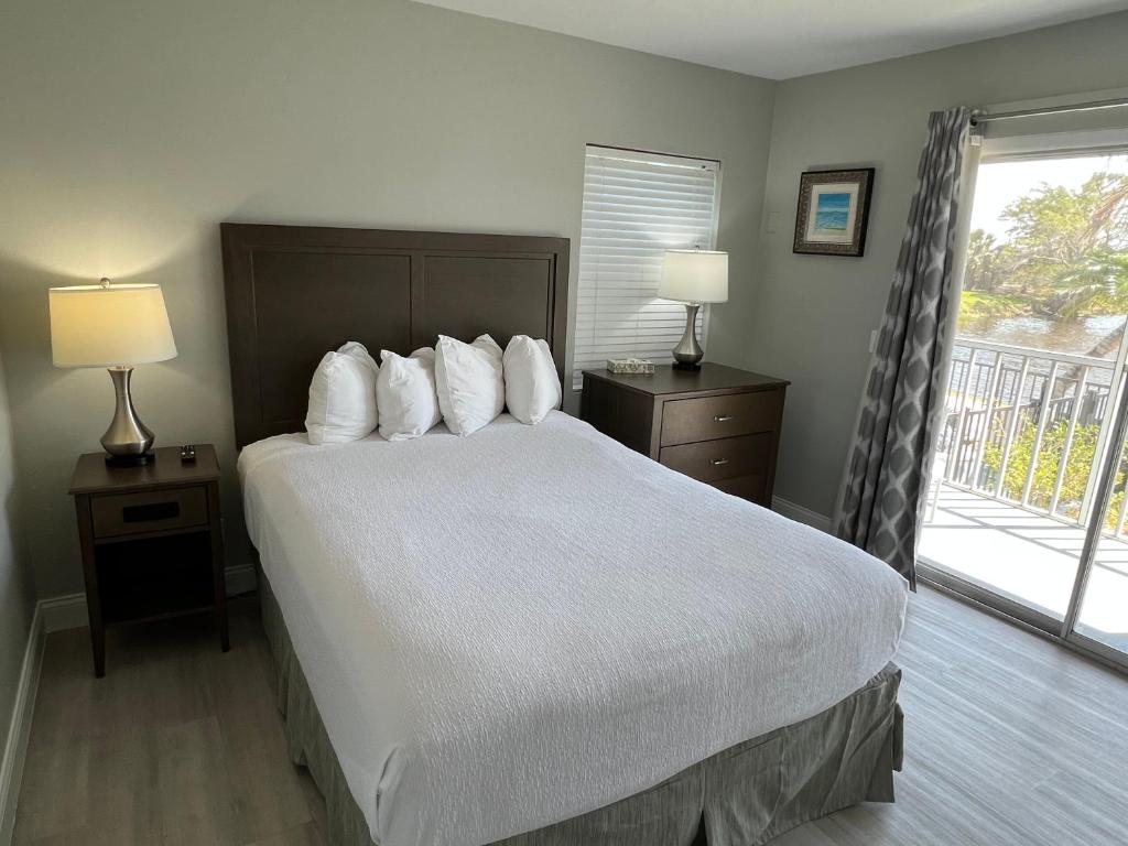 a bedroom with a large bed with white sheets and pillows at Marco Island Lakeside Inn in Marco Island