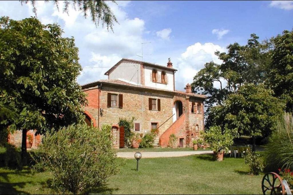 an old brick house in a yard with trees at Agriturismo Podere Caggiolo - Swimming Pool & Air Conditioning in Marciano