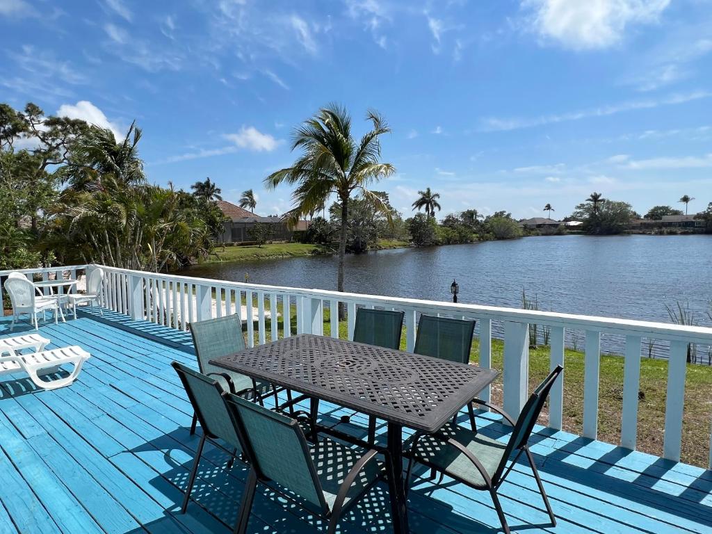 a table and chairs on a deck next to the water at Marco Island Lakeside Inn in Marco Island