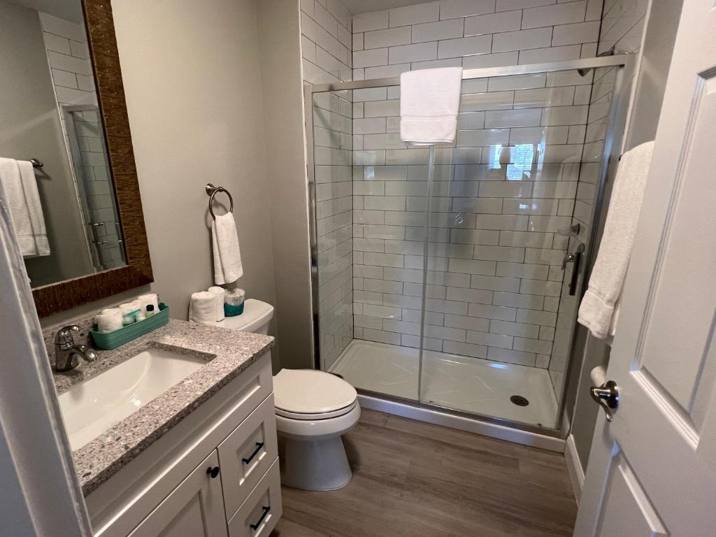 a bathroom with a shower and a toilet and a sink at Marco Island Lakeside Inn in Marco Island
