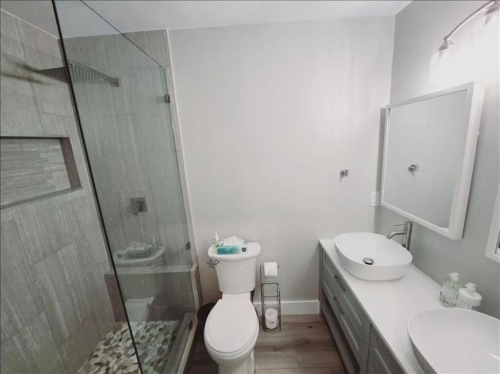 a bathroom with a toilet and a sink and a shower at J7 completely renovated, 2 pools, pickleball, fishing, fitness center,easy walk to pier in Mallory Park