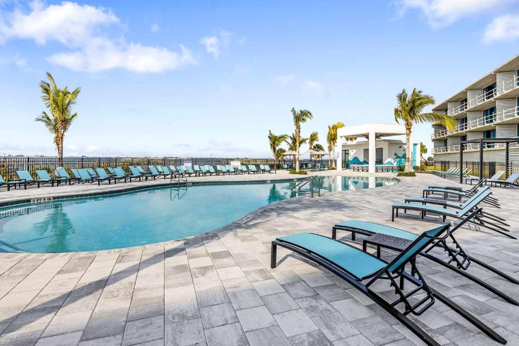 a swimming pool with lounge chairs and a resort at Villatel at Harbor Island Beach Club in Melbourne Beach
