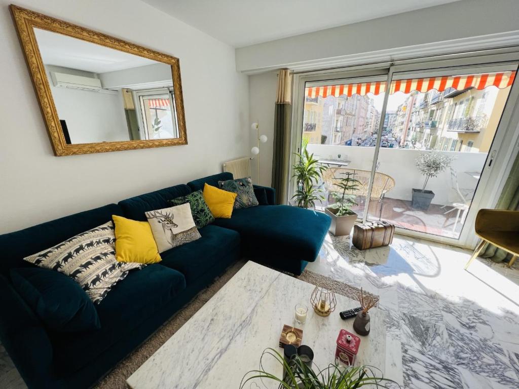 a living room with a blue couch and a mirror at John Homestay Room in Nice in Nice