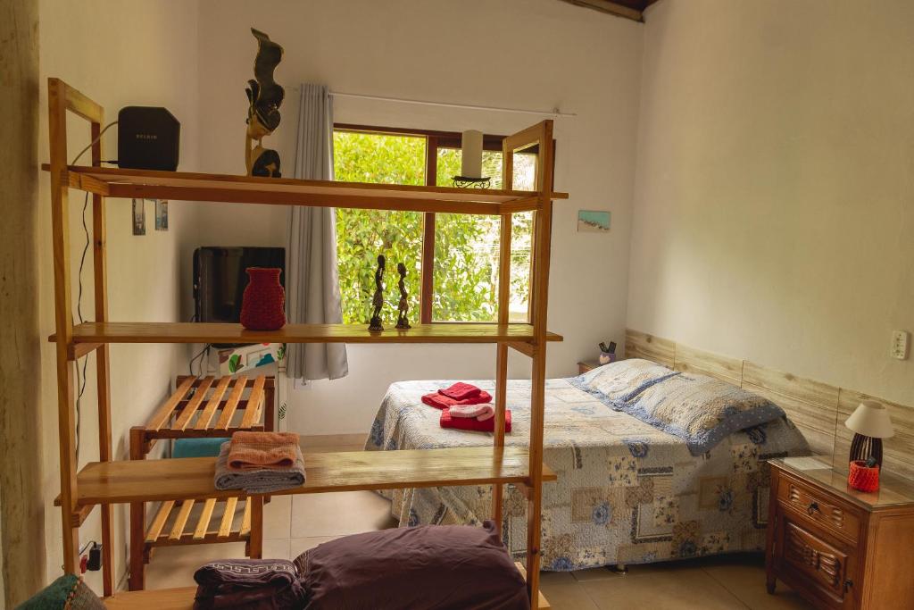 a bedroom with a bunk bed and a window at Suites surf house itamambuca in Ubatuba