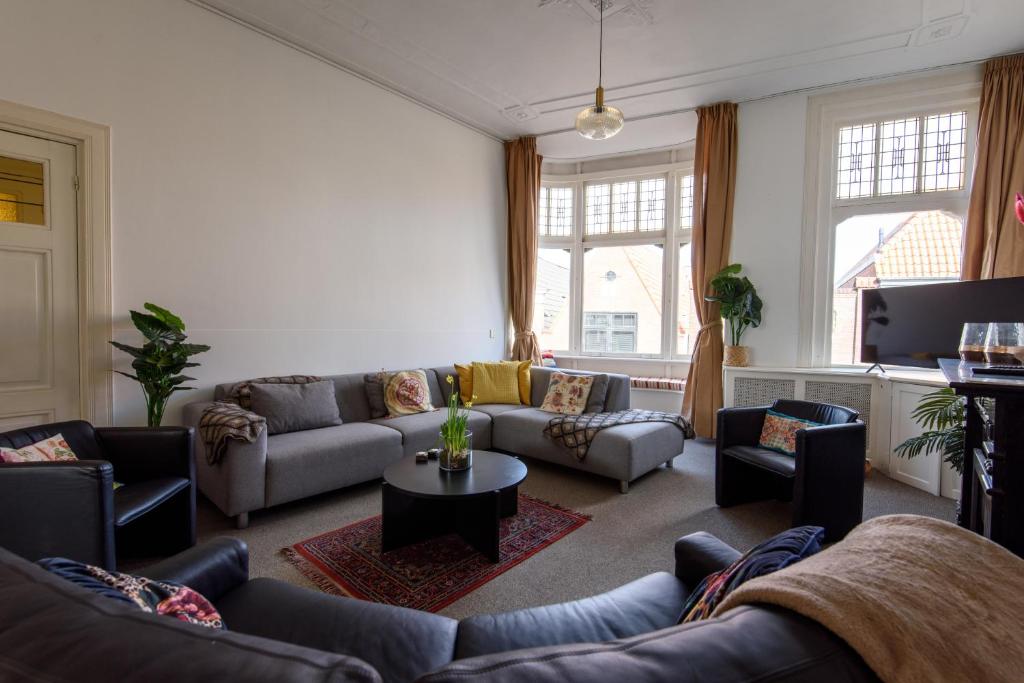 a living room with couches and a table at City House Hoorn in Hoorn
