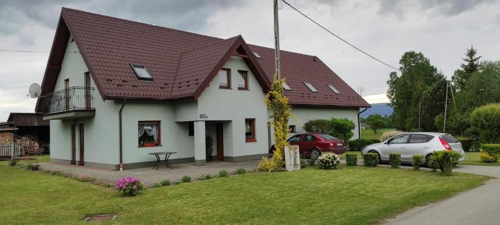 a white house with a brown roof at Nad Wilczym Potokiem in Miedzygorze