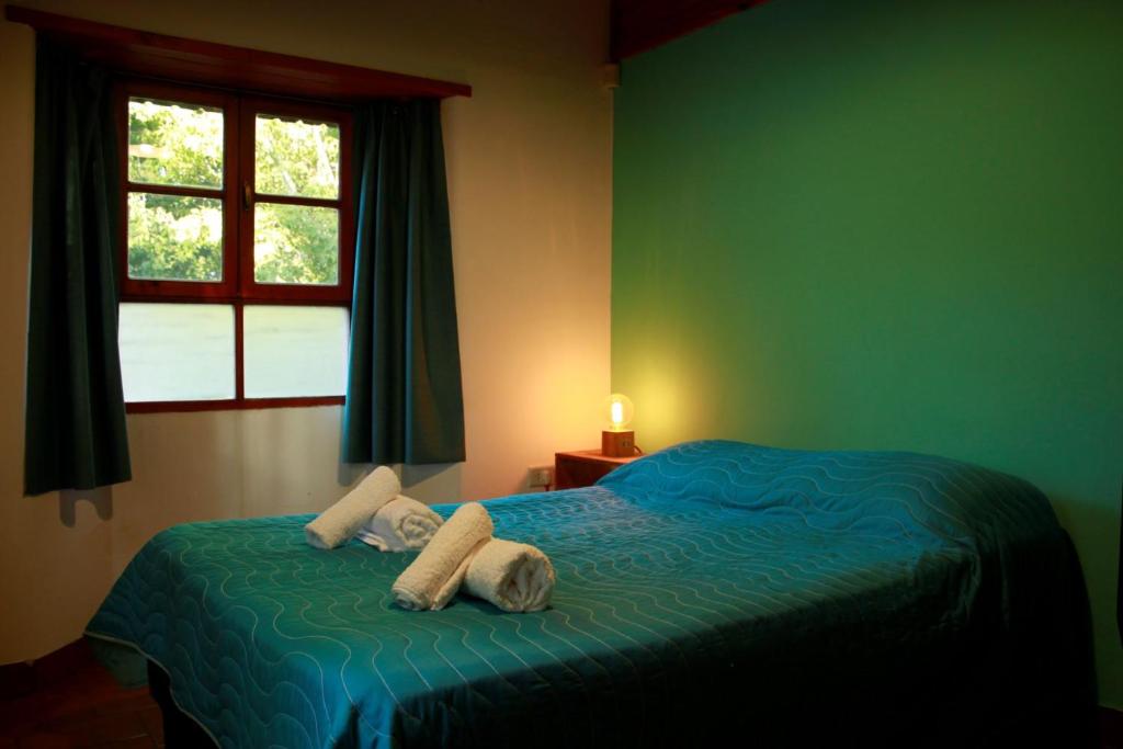 a bedroom with a bed with towels and a window at Casanicca Habitaciones privadas en Casa Compartida in San Martín de los Andes