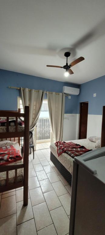 een slaapkamer met 2 bedden en een plafondventilator bij Hotel, Pousada e Restaurante Estrela Azul in Aparecida