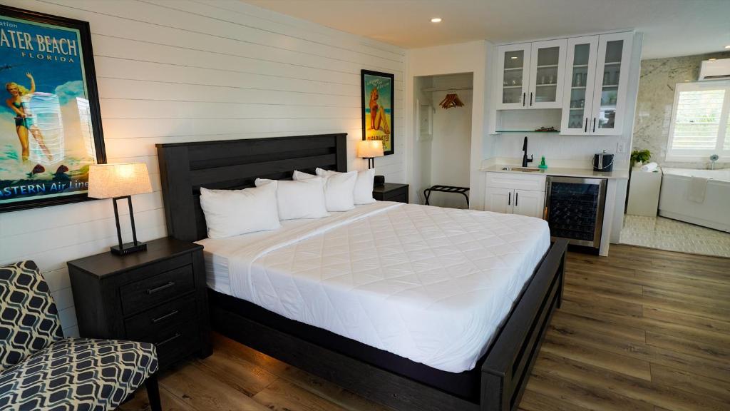 a bedroom with a large bed and a kitchen at Devon Shores in Clearwater Beach