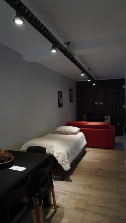 Un dormitorio con una cama y una mesa. en Casa Atilio -Dpto Premium con entrada autónoma en Rafaela