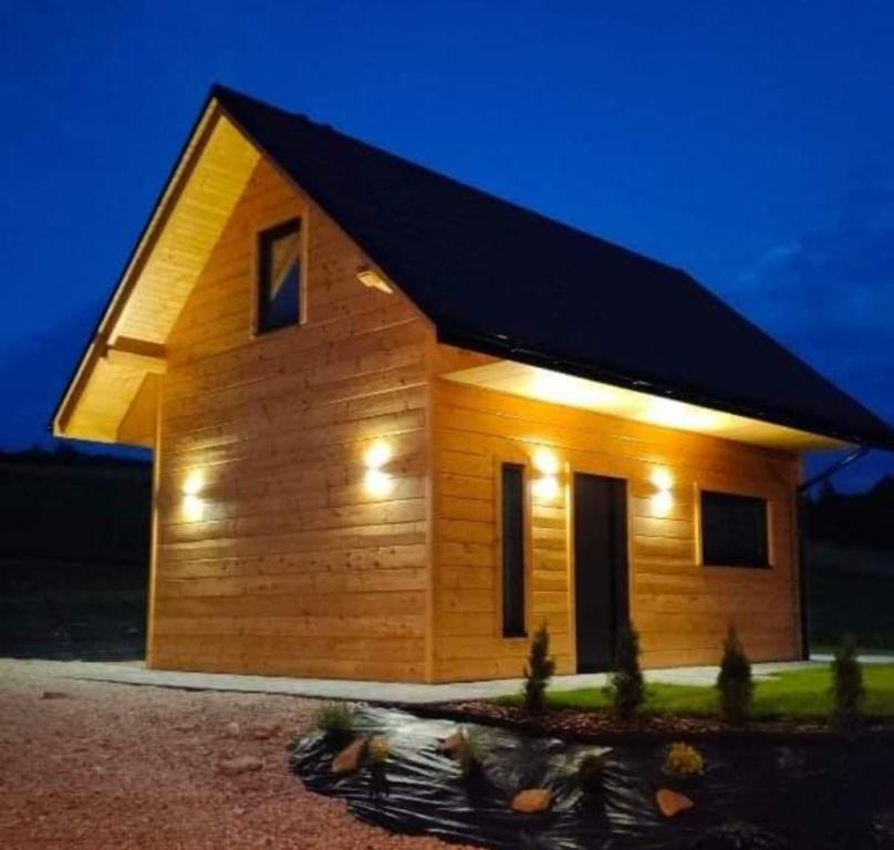 a small wooden house with lights on it at Jasna Chata Kluszkowce in Kluszkowce