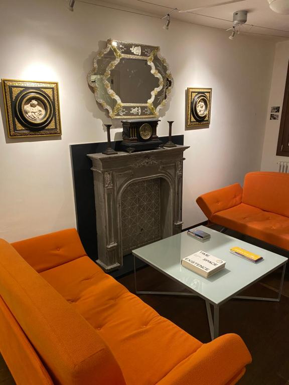 ein Wohnzimmer mit einem orangenen Sofa und einem Tisch in der Unterkunft The Other Serenissima (With A/C) in Venedig